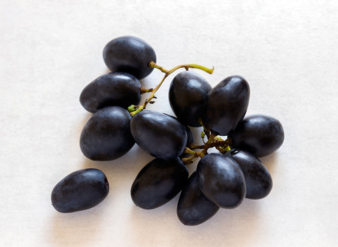 Black  grapes bunch on a light background.