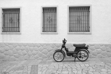 Typical Spanish old motorcycle parked in the street.