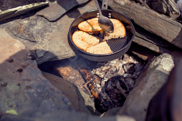 Fototapeta na wymiar Bread roasted on a pan in a burning campfire