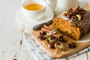 Spicy carrot cake with nuts on wood background