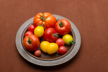 Verschiedene Tomatensorten auf einem rustikalen Teller. 