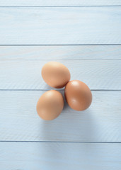 Huevos morenos sobre madera azul