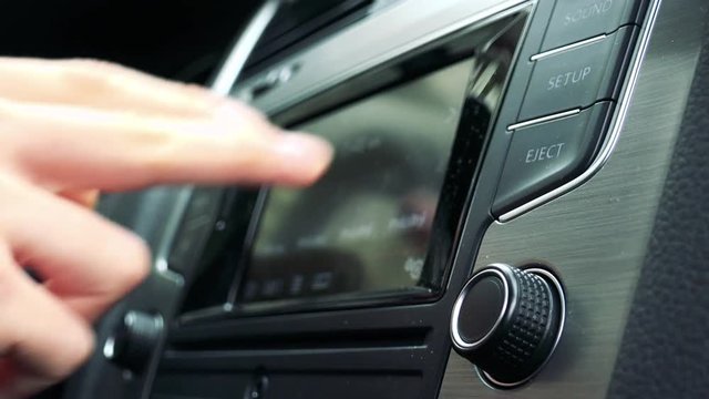 young man uses radio in the modern car - touch screen
