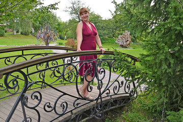 The woman of average years is installed on the decorative bridge