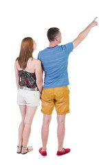 young couple in short pointing at wal Back view woman and man . Rear view people collection. backside view of person. Isolated over white background.