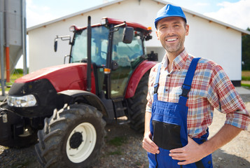 Man in unform and farm in the background.