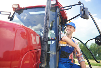 Young farmer sitting on the tractor