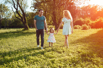 Happy young family spending time together outside in green nature.