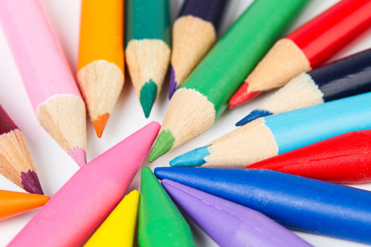 Lápices de colores y crayones sobre un fondo blanco. Vista superior y de cerca. Macro