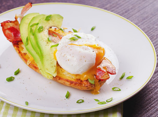 Stuffed potato with bacon, poached egg, avocado, cheese and spring onion