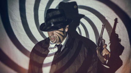 Retro Detective Spy With Gun Swirl. Man in white shirt, black tie and hat standing holding gun in...