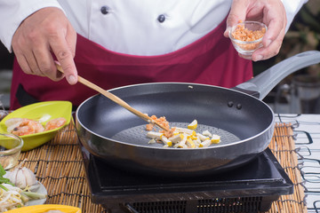Chef putting slice of dried radish to pan