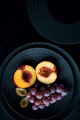 Fresh fruits on the black dish and black background. 