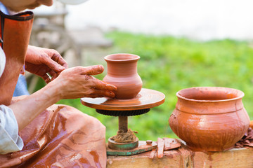 Fototapeta na wymiar Potter makes a pot, bowl of clay on a Potter's wheel