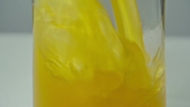 Tilt up shot of filling glass with fresh orange juice in slow motion