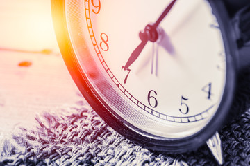 closeup vintage clock selective focus at number 7 o'clock with sun light vintage color tone for...