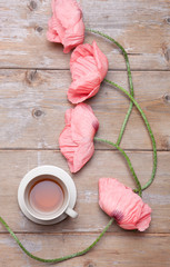 Delicious black tea with poppy flowers on a table
