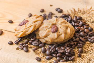 Fototapeta na wymiar coffee cookie with almond nut with coffee bean on wood background