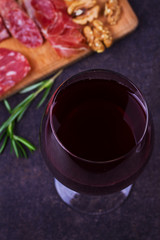 Red wine with blue cheese, parmesan, salami, prosciutto, olives, rosemary and bread. View from above, top studio shot