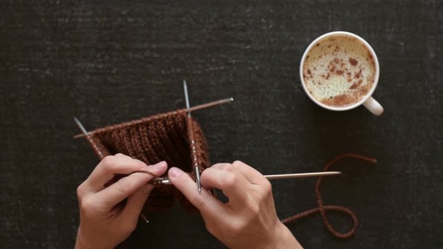 Knitting and coffee on black background