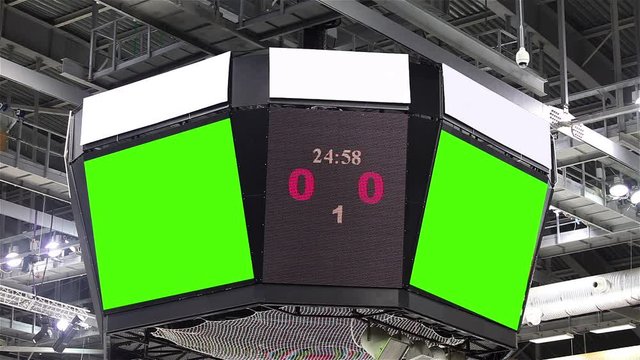 Scoreboard at the stadium with a green screen and banners.