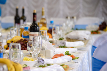 Served dishes to the table for holiday. Cutlery and food on white tablecloths in the restaurant. Design a festive Banquet. Luxurious food for guests and visitors.