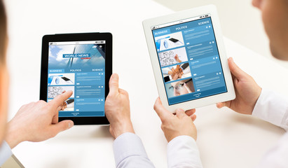 close up of hands with business news on tablet pc