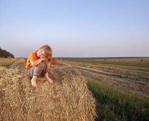 Naklejka na ściany i meble boy in a haystack in the field