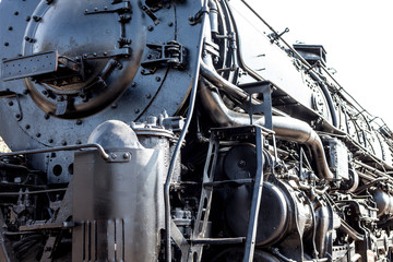 Detail of steam train engine; the strength and power of metal, engineering, coal and manpower for transporting passengers and goods across the USA.