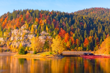 Colorful autumn mountain landscape with multicolored trees, blue sky and reflection in the water, National park Slovak paradise, Slovakia