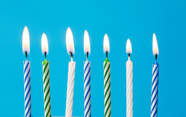 birthday candles burning over blue background