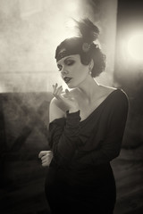 Beautiful Flapper girl. Old photo in a retro style. Smoky eyes and hair cold wave.