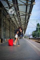 Fototapeta na wymiar Couple stands on the empty platform under the clock.