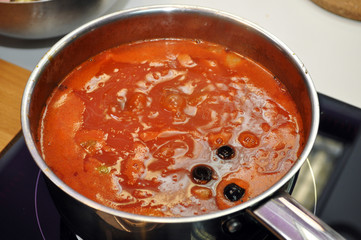 red soup is cooked in a pan