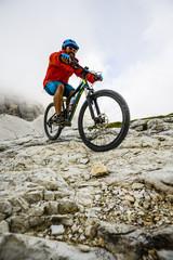 Fototapeta premium Mountain Bike cyclist riding single track on rocks healthy lifestyle active vacation in italian Alps