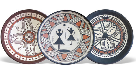 Old handmade ornated pottery plate isolated on white