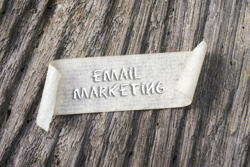 TORN paper with EMAIL MARKETING word on wooden background. 