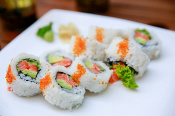 Rolls with salmon, avocado and caviar over white background