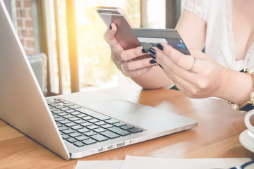 Fototapeta premium Online payment,Woman's hands holding a credit card and using sma