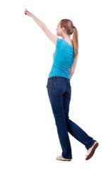 back view of walking  woman  in   jeans and shirt pointing. beautiful blonde girl in motion.  backside view of person.  Rear view people collection. Isolated over white background. blonde with long