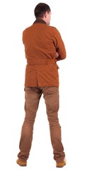 Back view of stylishly dressed man in a brown jackett  looking up.   Standing young guy in jeans and  jacket. Rear view people collection.  backside view of person.  Isolated over white background.