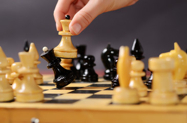 Playing chess. White queen Hitting the black one in front of the rest figures