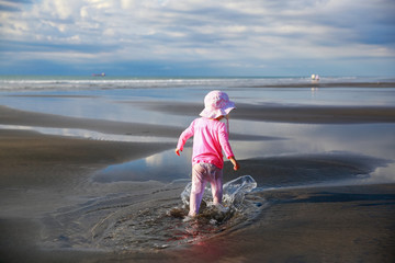 Cute Little girl walking on New Plymouth beach, NZ