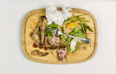 remnants of food on a tray, chicken bones