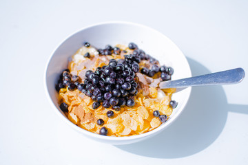 Fit breakfast. Bowl full of corn flakes, yogurt and blueberries.