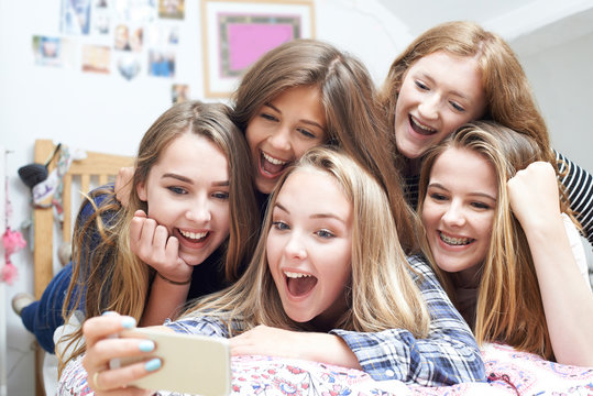 Group Of Teenage Girls Taking Selfie On Mobile Phone