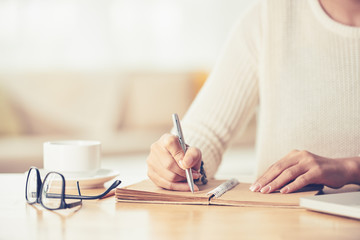 Woman writing her plans for the day in notebook