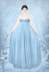 Fototapeta na wymiar Woman in blue bridal dress - fantasy winter 