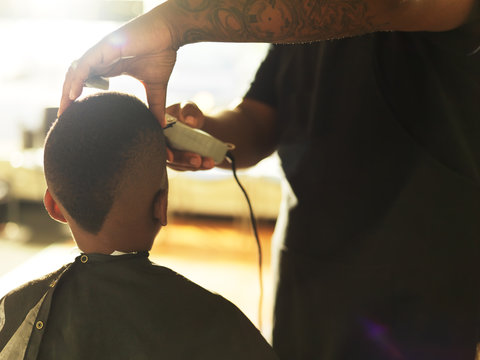 little boy getting hair cut by barber