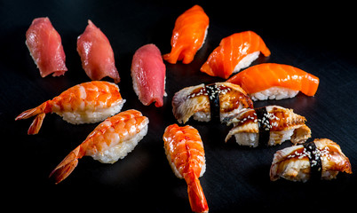 Japanese rolls with fish on a black background